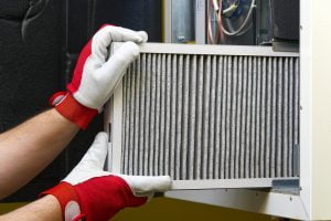 Technician replacing dirty HVAC air filter